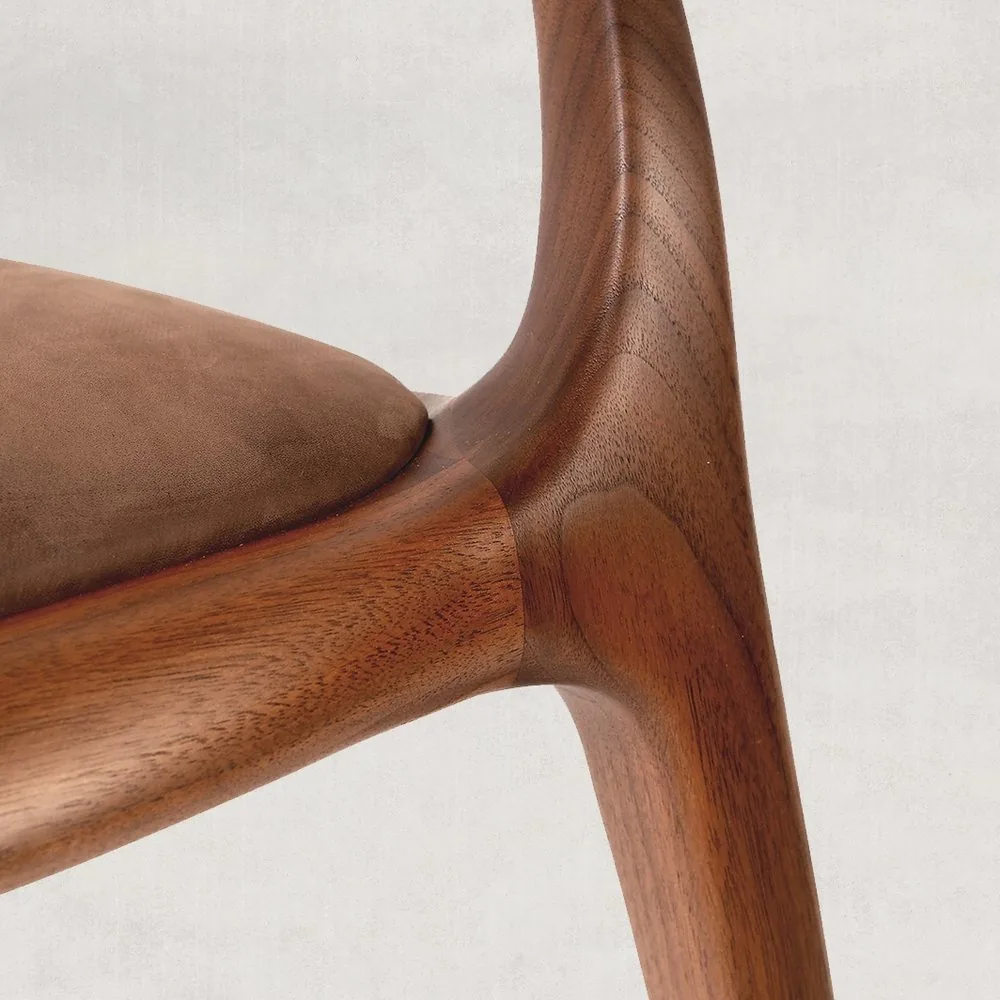 Finished walnut joint between the front leg and the solid-wood seat